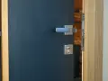 Porte d'entrée moderne bleu foncé avec poignée argentée et serrure. Idéal pour apprendre comment nettoyer des portes en bois.
