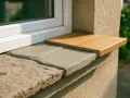 Nouvel appui de fenêtre extérieur en bois clair, remplaçant l'ancien en pierre usée.