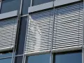 Volets roulants modernes sur une façade de bâtiment. L'image suggère la durabilité et la longévité du moteur de volet roulant.