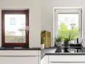 Avant/après : une fenêtre en bois marron est transformée en une fenêtre blanche lumineuse, apportant plus de clarté à la cuisine.