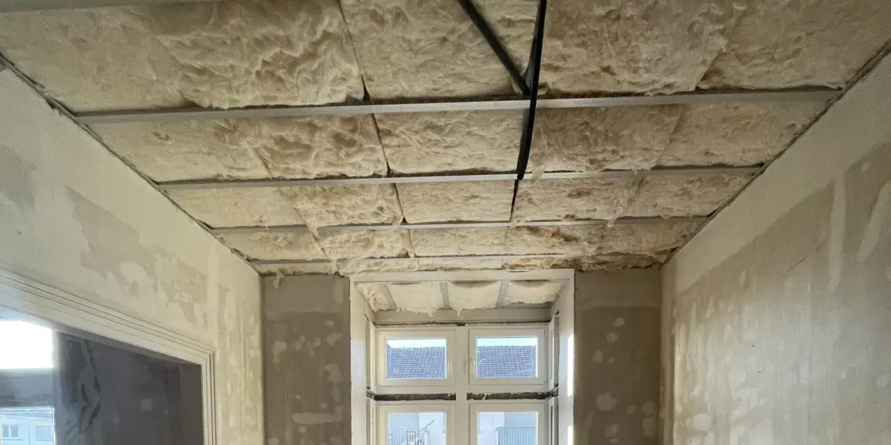 Isolation de plafond en laine de roche, réduisant le bruit de 3 décibels. Exemple de chantier.