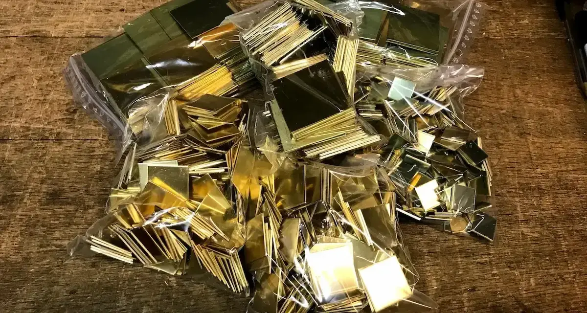 Plusieurs sacs de petits carrés de laiton brillants, prêts pour un projet. Idéal pour apprendre comment nettoyer du laiton.