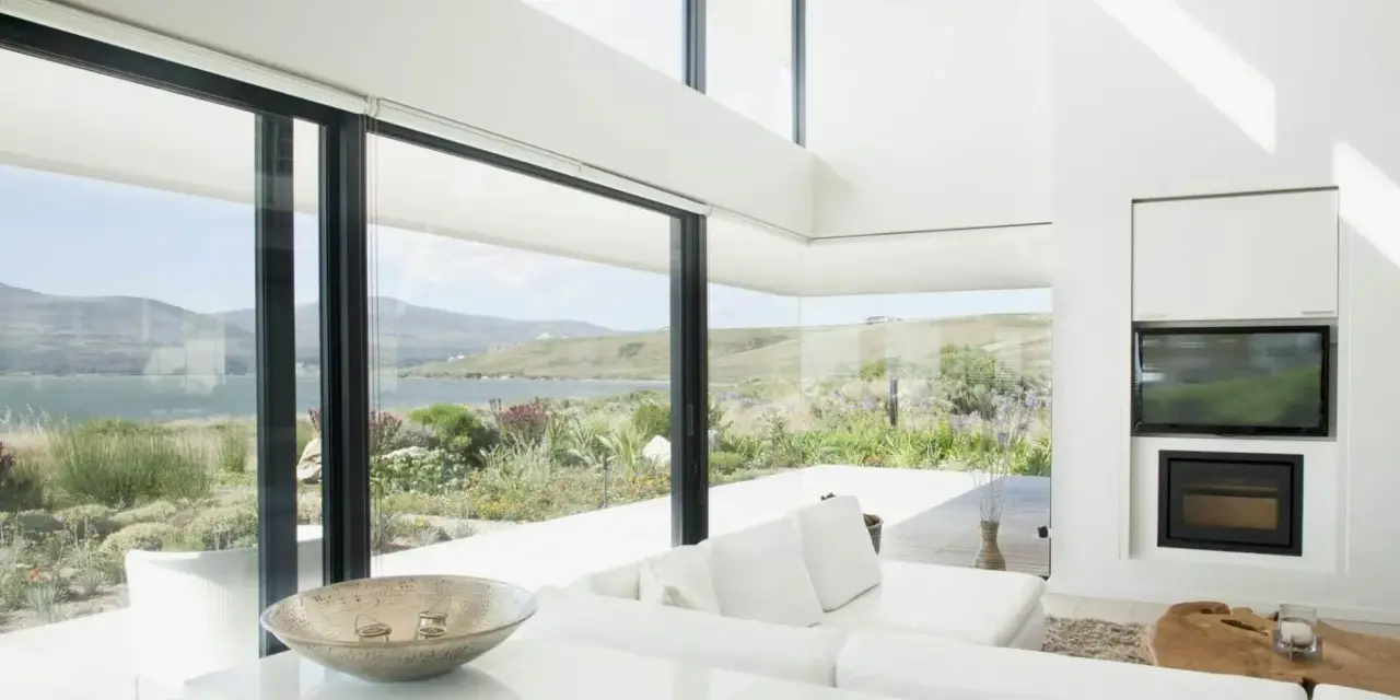 Salon moderne avec vue panoramique sur la mer, le choix du vitrage maximise la lumière naturelle et le paysage.