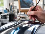 Main d'artiste peignant un objet à la finition chrome, ajoutant des détails subtils pour un réalisme saisissant.