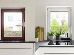 Avant/après : une fenêtre en bois marron est transformée en une fenêtre blanche lumineuse, apportant plus de clarté à la cuisine.