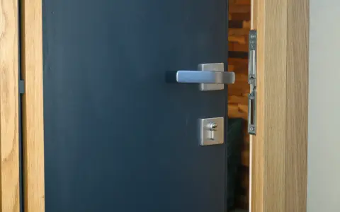 Porte d'entrée moderne bleu foncé avec poignée argentée et serrure. Idéal pour apprendre comment nettoyer des portes en bois.