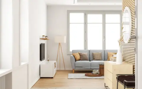 Salon lumineux avec un canapé gris, une table basse et une grande fenêtre ouverture à la française baignant la pièce de lumière naturelle.