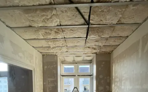 Isolation de plafond en laine de roche, réduisant le bruit de 3 décibels. Exemple de chantier.