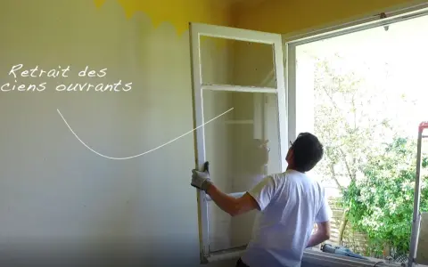 Retrait des anciens ouvrants : un homme retire une vieille fenêtre.
