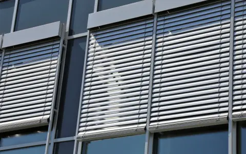 Volets roulants modernes sur une façade de bâtiment. L'image suggère la durabilité et la longévité du moteur de volet roulant.