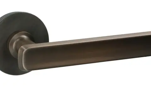 Poignée de porte moderne en bronze, avec une tige poignée de porte trop longue, au design épuré et contemporain.