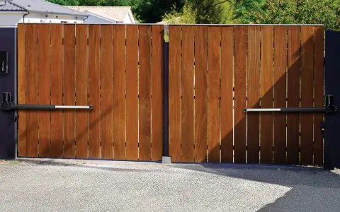 Portail en bois avec motorisation à vérin. Installation discrète pour un accès automatisé.