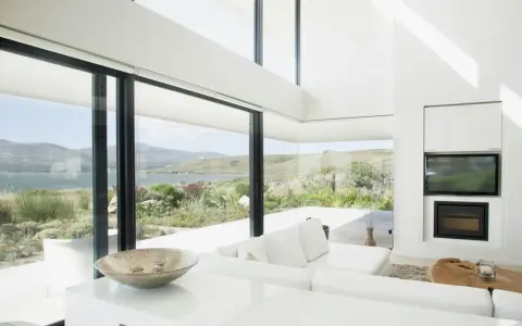 Salon moderne avec vue panoramique sur la mer, le choix du vitrage maximise la lumière naturelle et le paysage.