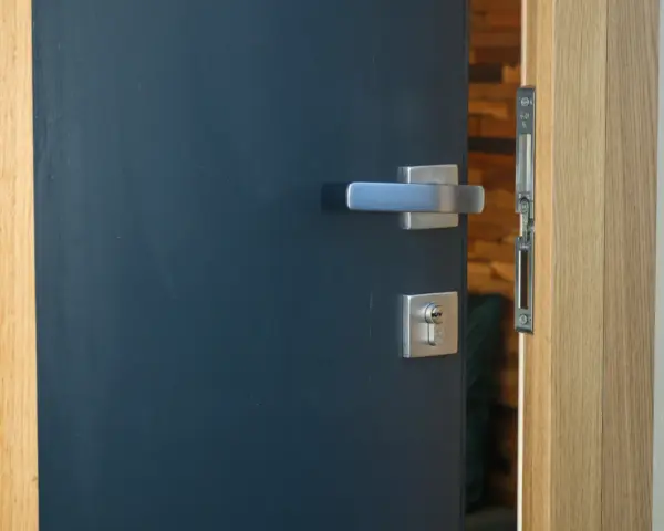Porte d'entrée moderne bleu foncé avec poignée argentée et serrure. Idéal pour apprendre comment nettoyer des portes en bois.