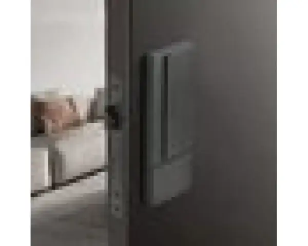 Poignée de porte grise sur fond sombre, avec une serrure silencieuse visible sur le côté.