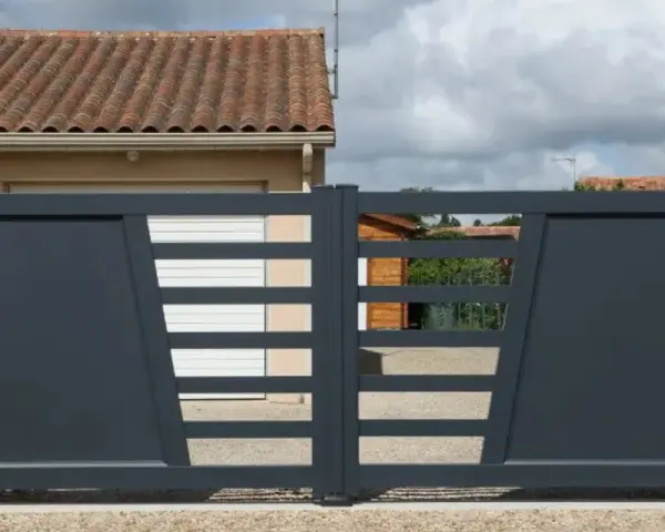 Portail solaire ne fonctionne plus. La grille grise moderne, avec ses lames horizontales et son design asymétrique, est fermée devant une maison.