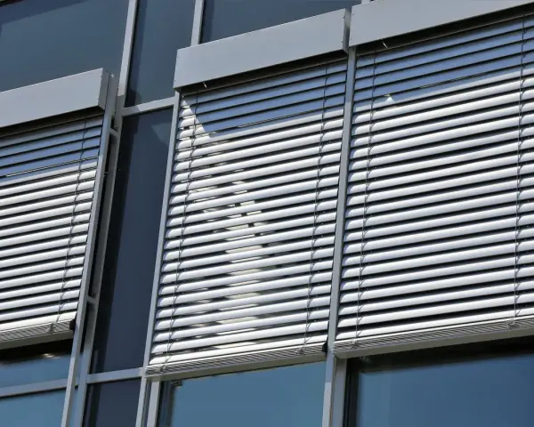 Volets roulants modernes sur une façade de bâtiment. L'image suggère la durabilité et la longévité du moteur de volet roulant.