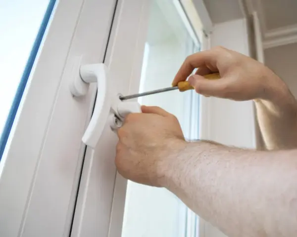 Une poignée de porte vis tourne dans le vide, indiquant un problème de fixation. Un tournevis est utilisé pour tenter de la resserrer.