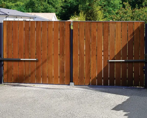 Portail en bois avec motorisation à vérin. Installation discrète pour un accès automatisé.
