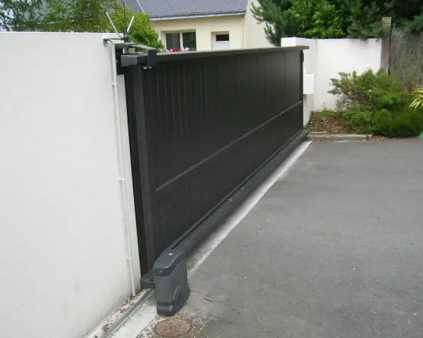 Portail coulissant noir avec son moteur, garantissant la puissance moteur portail coulissant pour une ouverture fluide.