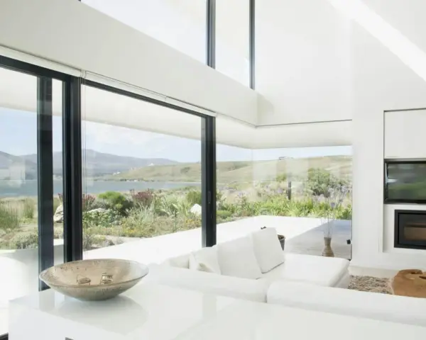 Salon moderne avec vue panoramique sur la mer, le choix du vitrage maximise la lumière naturelle et le paysage.