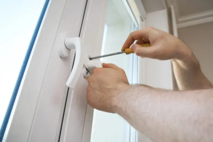Une poignée de porte vis tourne dans le vide, indiquant un problème de fixation. Un tournevis est utilisé pour tenter de la resserrer.