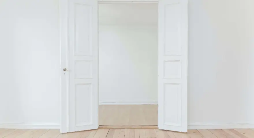Porte intérieure blanche ouverte, tendance couleur gris clair, sur parquet clair. Un espace minimaliste et lumineux.