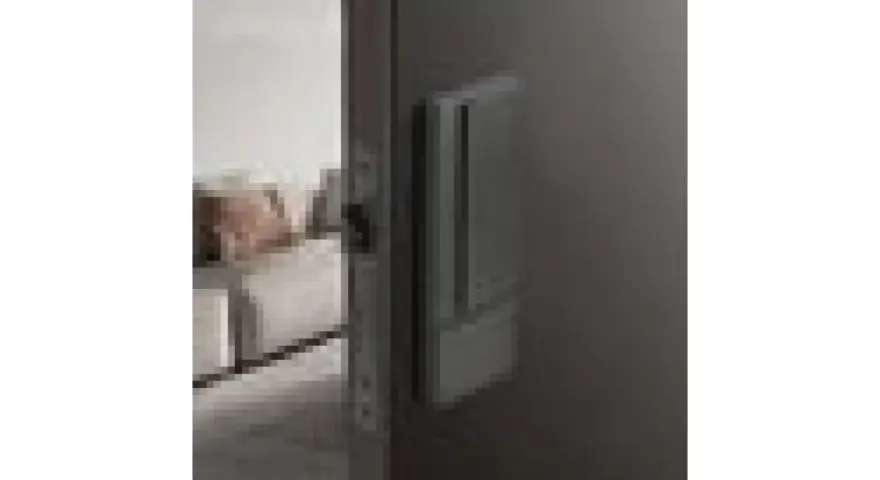 Poignée de porte grise sur fond sombre, avec une serrure silencieuse visible sur le côté.