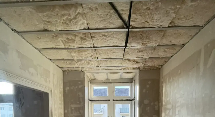 Isolation de plafond en laine de roche, réduisant le bruit de 3 décibels. Exemple de chantier.