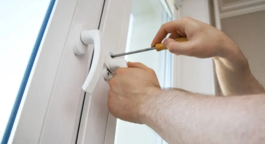 Une poignée de porte vis tourne dans le vide, indiquant un problème de fixation. Un tournevis est utilisé pour tenter de la resserrer.