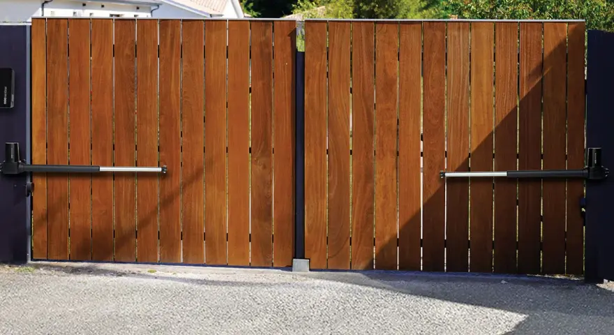 Portail en bois avec motorisation à vérin. Installation discrète pour un accès automatisé.