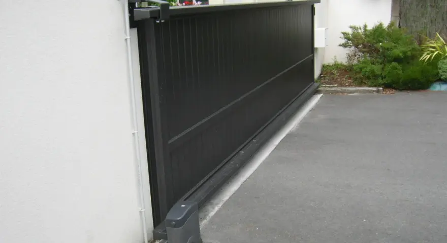 Portail coulissant noir avec son moteur, garantissant la puissance moteur portail coulissant pour une ouverture fluide.