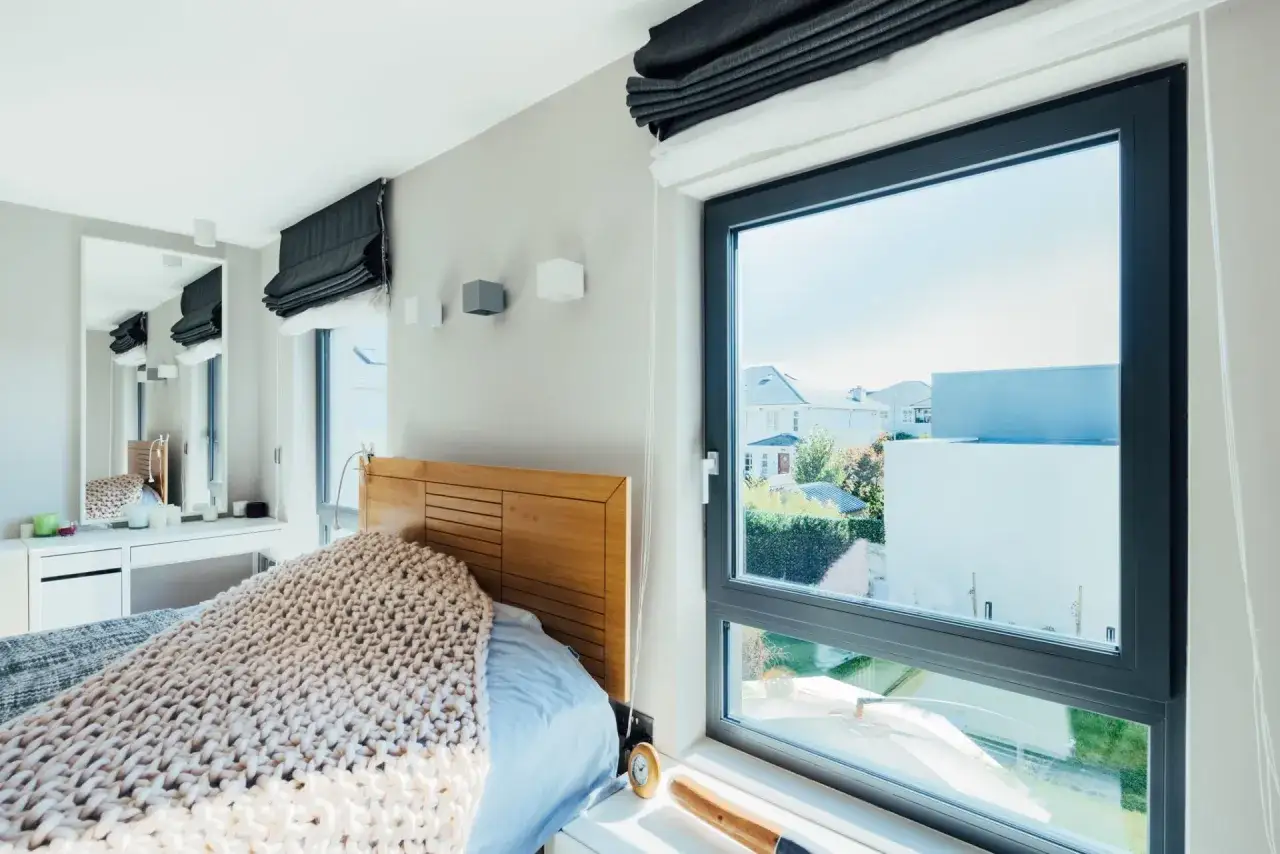 Chambre lumineuse avec un lit douillet, une coiffeuse et une grande fen&ecirc;tre avec all&egrave;ge pleine offrant une vue sur le jardin.