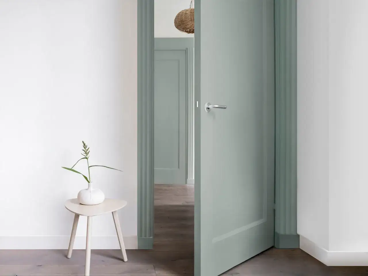 Une porte vert sauge ouverte, un petit gu&eacute;ridon avec un vase, une invitation &agrave; relooker porte et int&eacute;rieur.