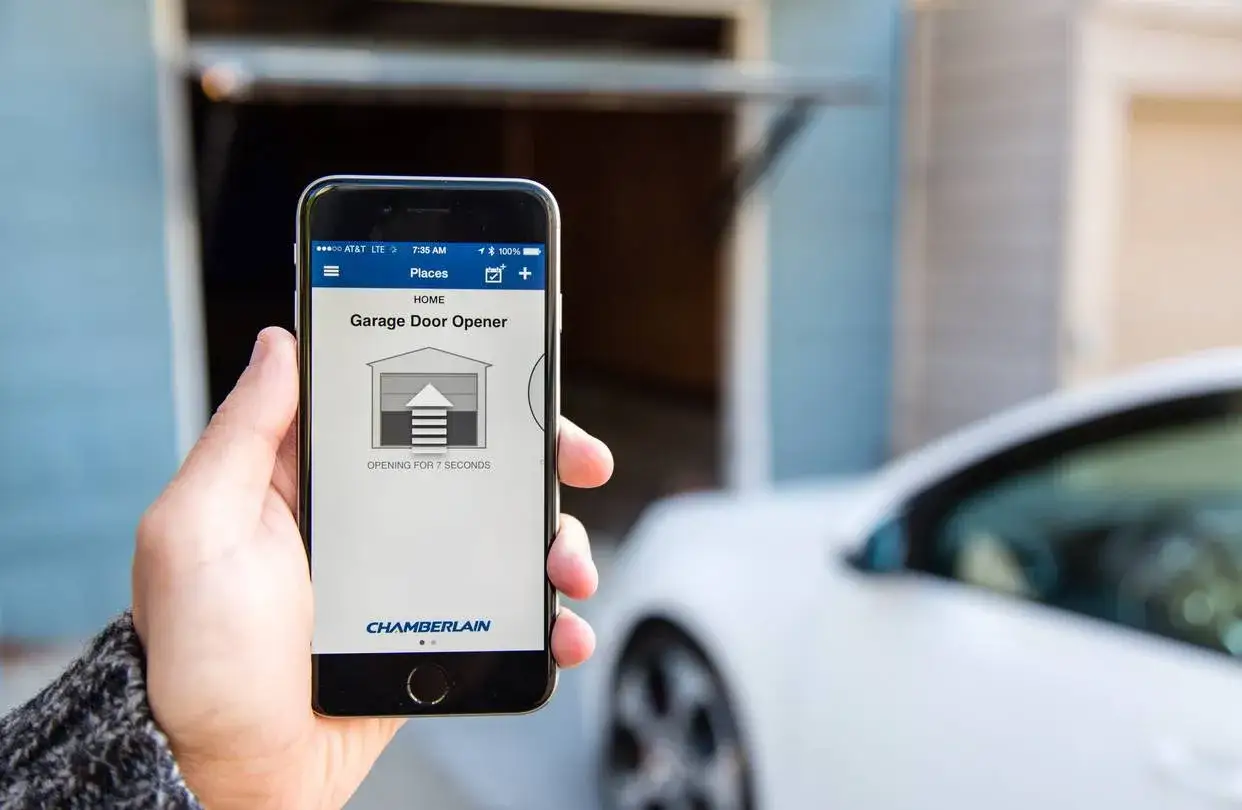 Utilisation d'un smartphone pour ouvrir la porte de garage. L'application Chamberlain indique que la porte s'ouvre.