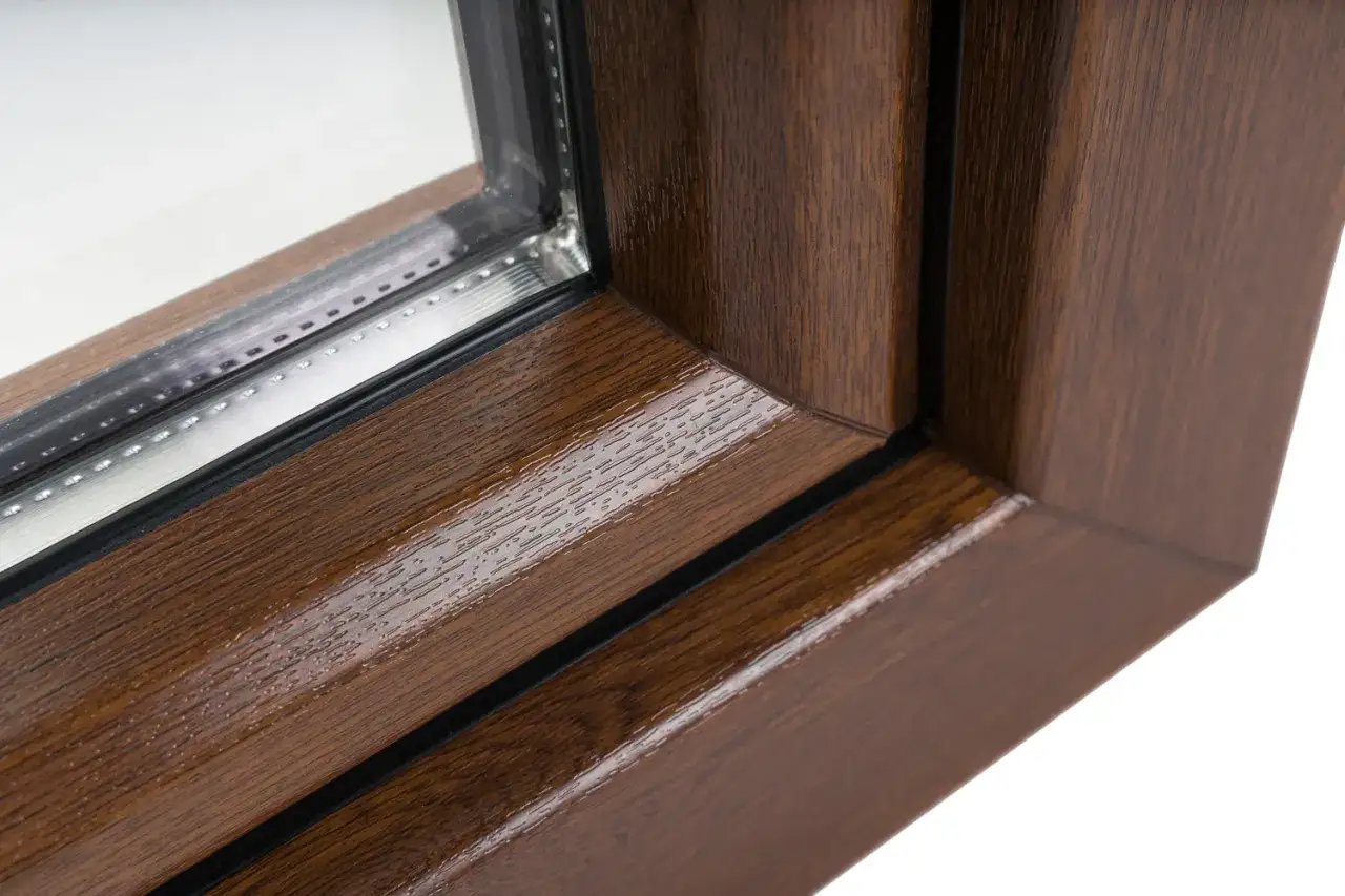 Gros plan sur le coin d'une fen&ecirc;tre. Le cadre pr&eacute;sente une texture de bois r&eacute;aliste dans une riche couleur fenetre bois.