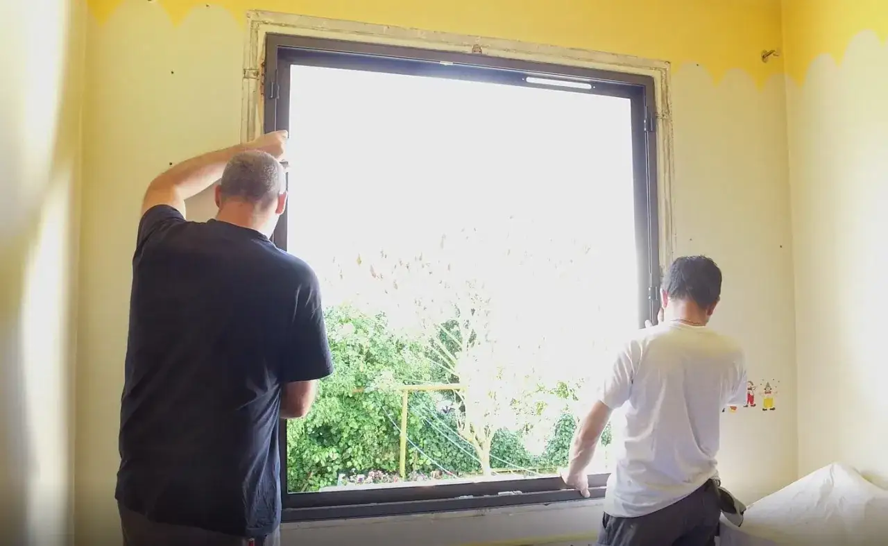 Deux hommes travaillent pour changer une fen&ecirc;tre, une t&acirc;che r&eacute;alisable soi-m&ecirc;me.