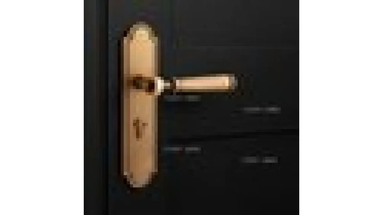 Poignée de porte dorée sur fond sombre, évoquant une serrure silencieuse.